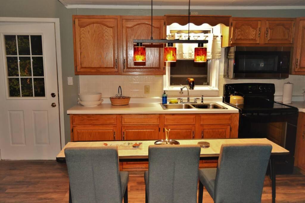 a kitchen with wooden cabinets and a table with chairs at The Bungalow in Grand Forks