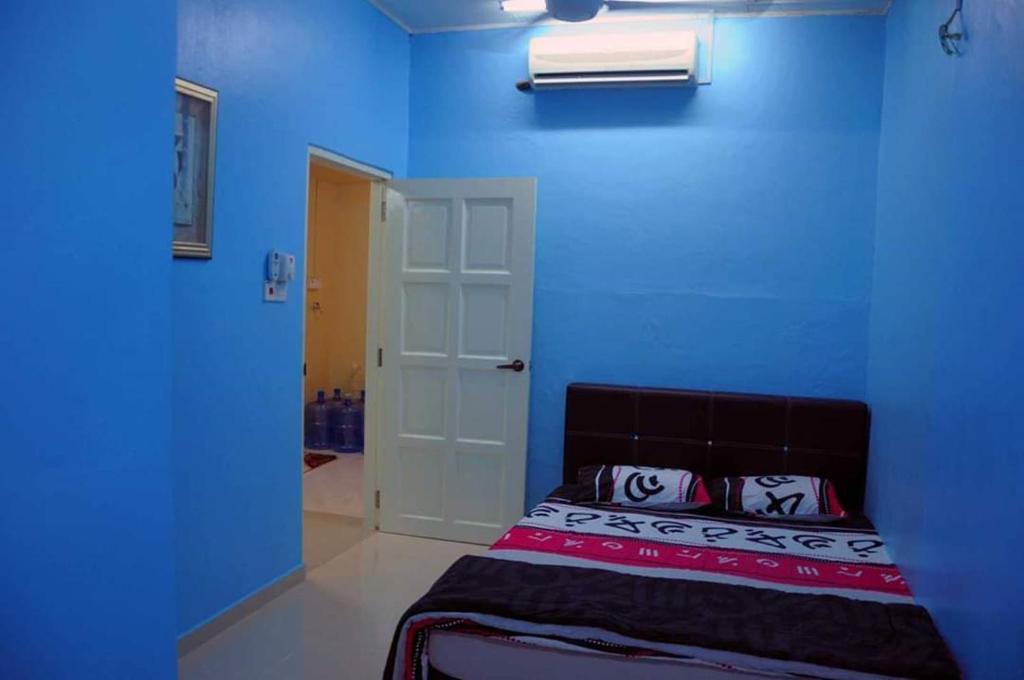 a blue room with a bed and a white door at RH Homestay Berhawa Dingin in Kota Bharu