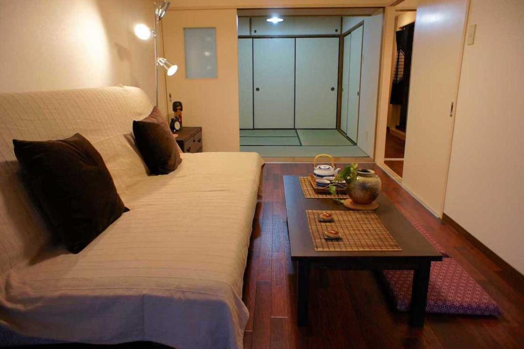 Schlafzimmer mit einem Bett und einem Tisch mit einer Glastür in der Unterkunft Nishi-Ikebukuro 3 in Tokio