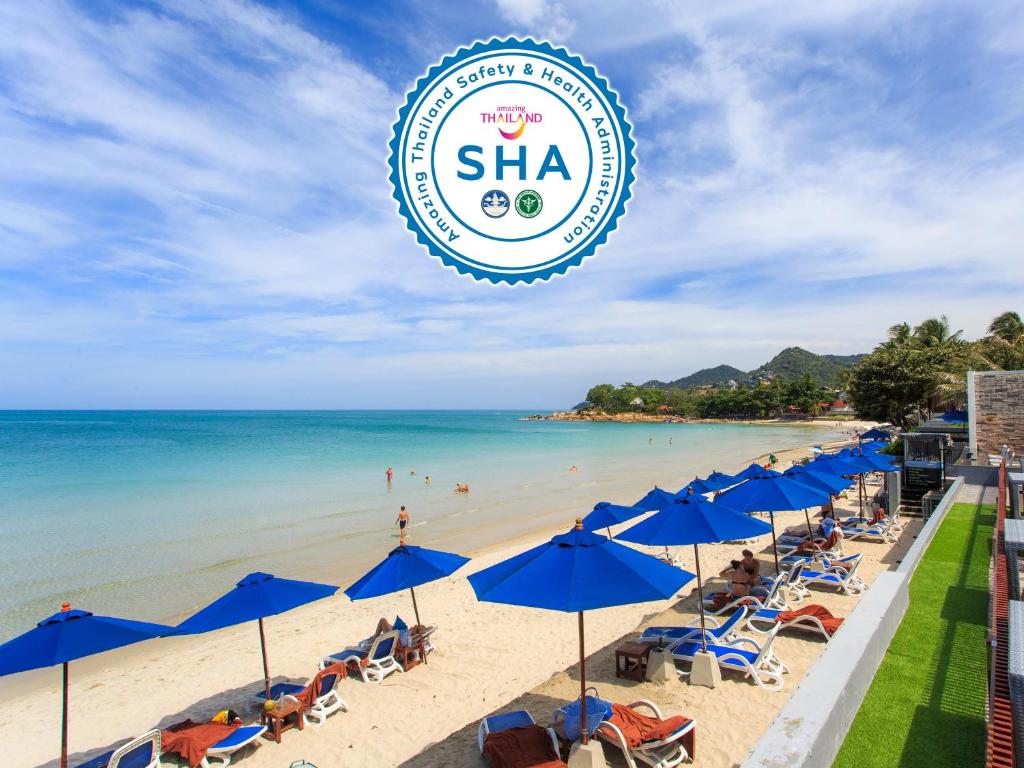 a beach with blue umbrellas and the sha sign at Samui Resotel Beach Resort in Chaweng