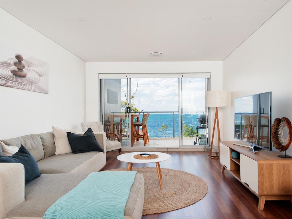 a living room with a couch and a table at 501 The Shoal in Shoal Bay