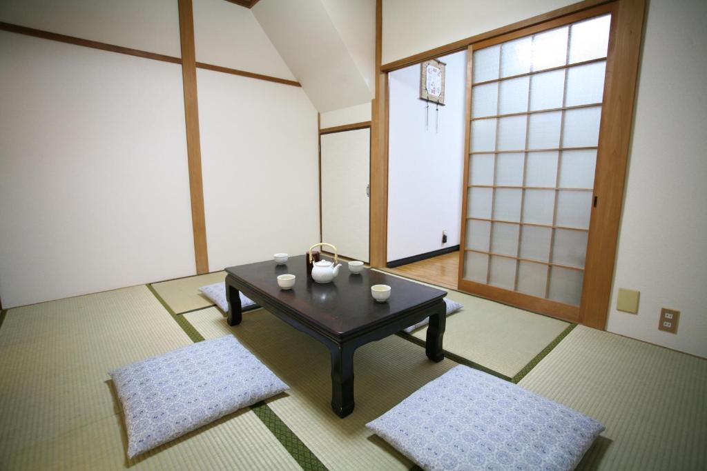 un soggiorno con tavolo e 2 tappeti di Demachi 2 a Kyoto