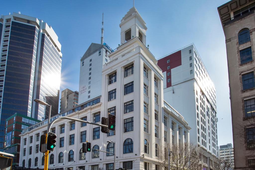 um edifício branco com uma torre de relógio numa cidade em Attic Backpackers em Auckland