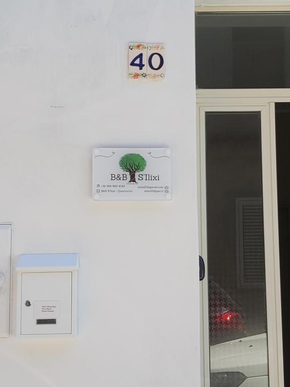 un panneau sur un mur à côté d'une porte dans l'établissement S'Ilixi, à Quartucciu