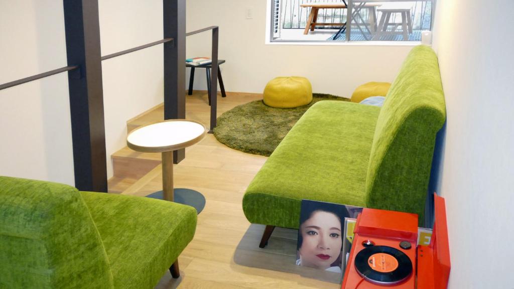 un soggiorno con mobili verdi e un divano verde di Teppanyaki House a Kyoto