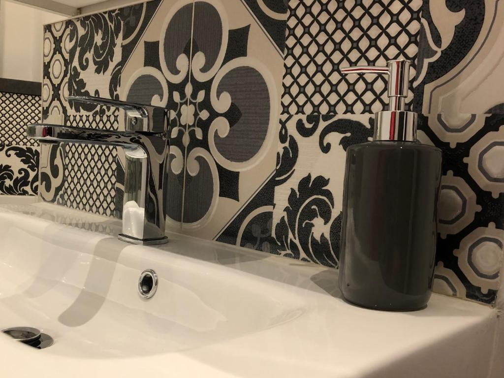 a bathroom sink with a black soap dispenser on it at Parking Privé - Vue mer - WiFi - Centre Historique in Grasse