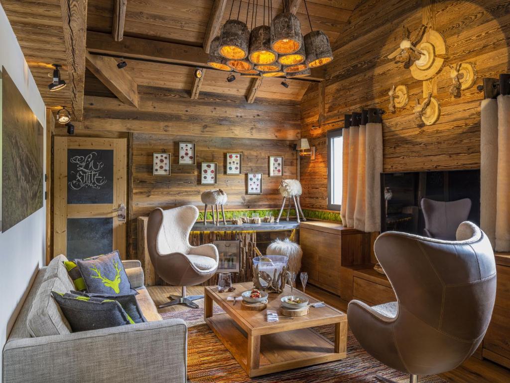 - un salon avec des murs en bois, une table et des chaises dans l'établissement Les Rhodos, à La Clusaz