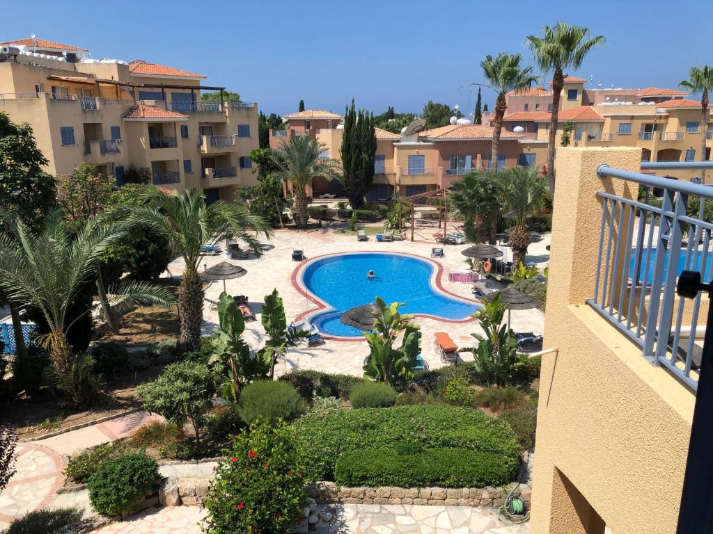 een balkon met uitzicht op het zwembad van een resort bij Charming pool facing apartment in Limnaria Gardens in Paphos City