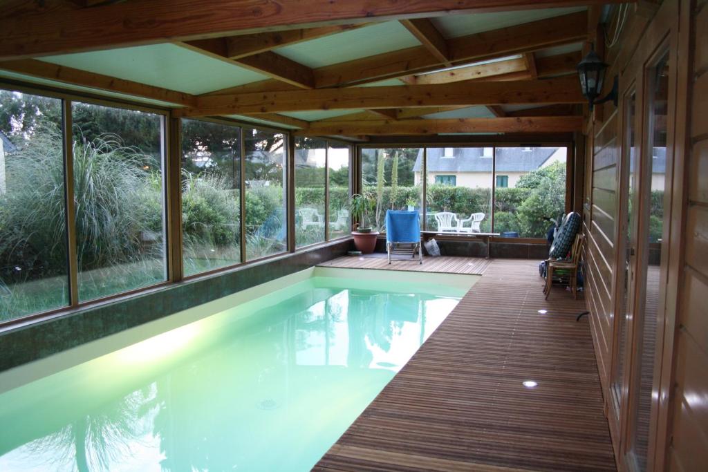 a pool in a house with a deck and windows at Les Villas d' Onalou Port Blanc in Penvénan