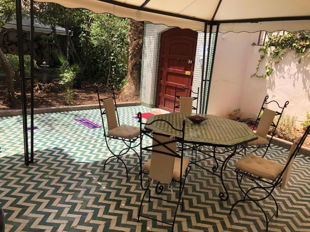 a patio with a table and chairs on a tile floor at Youth Hostel International Fez in Fez