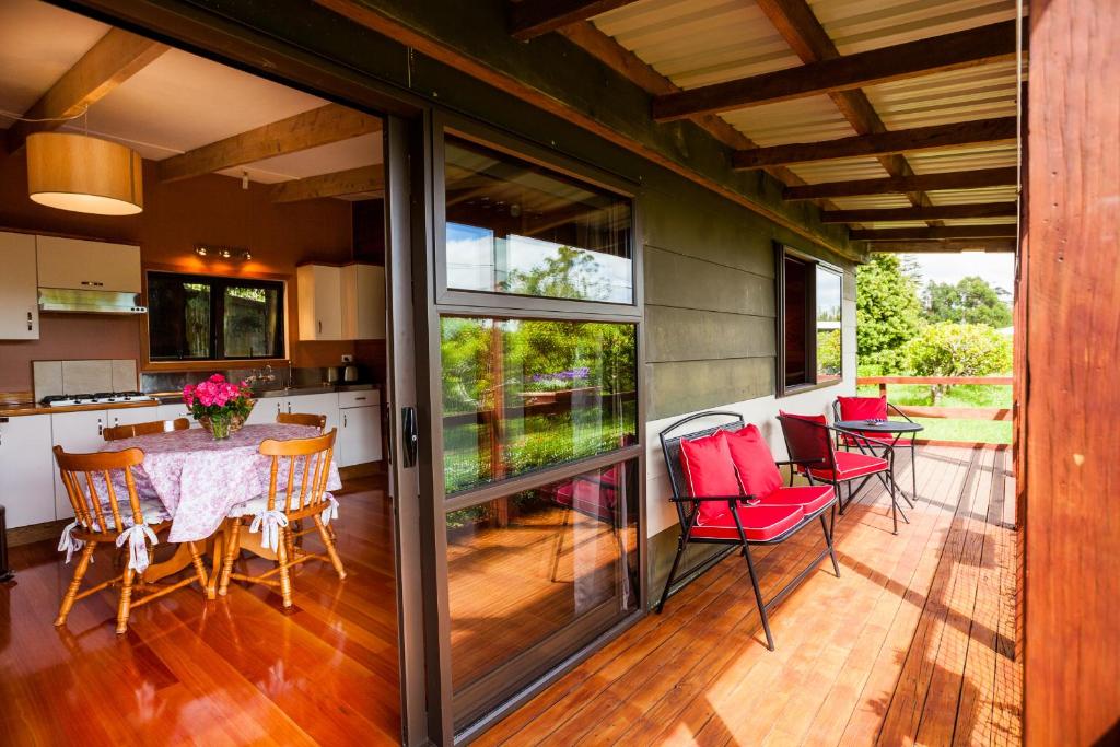 a screened in porch with a table and chairs at Relax a Lodge in Kerikeri