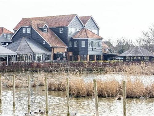 Oyster Fleet Hotel في Canvey Island: مجموعة منازل وبط في الماء