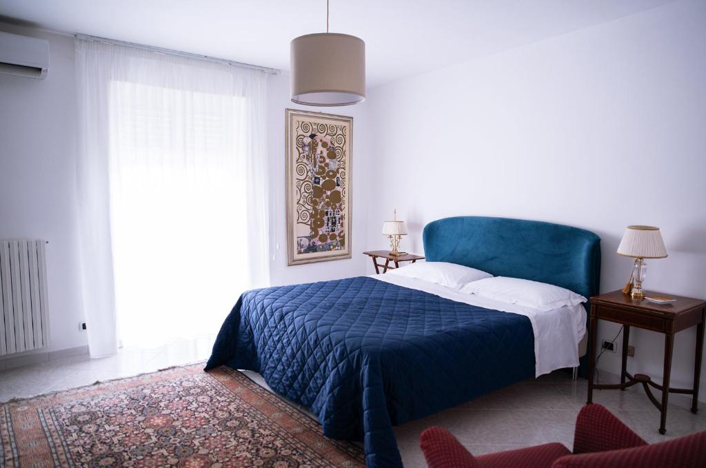 a bedroom with a blue bed and a window at Mirò B&B in Acquaviva delle Fonti