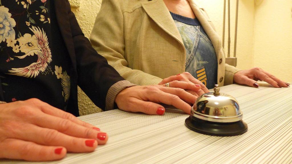 a person sitting at a table with a tea kettle at Hostal Rosa in Villajoyosa