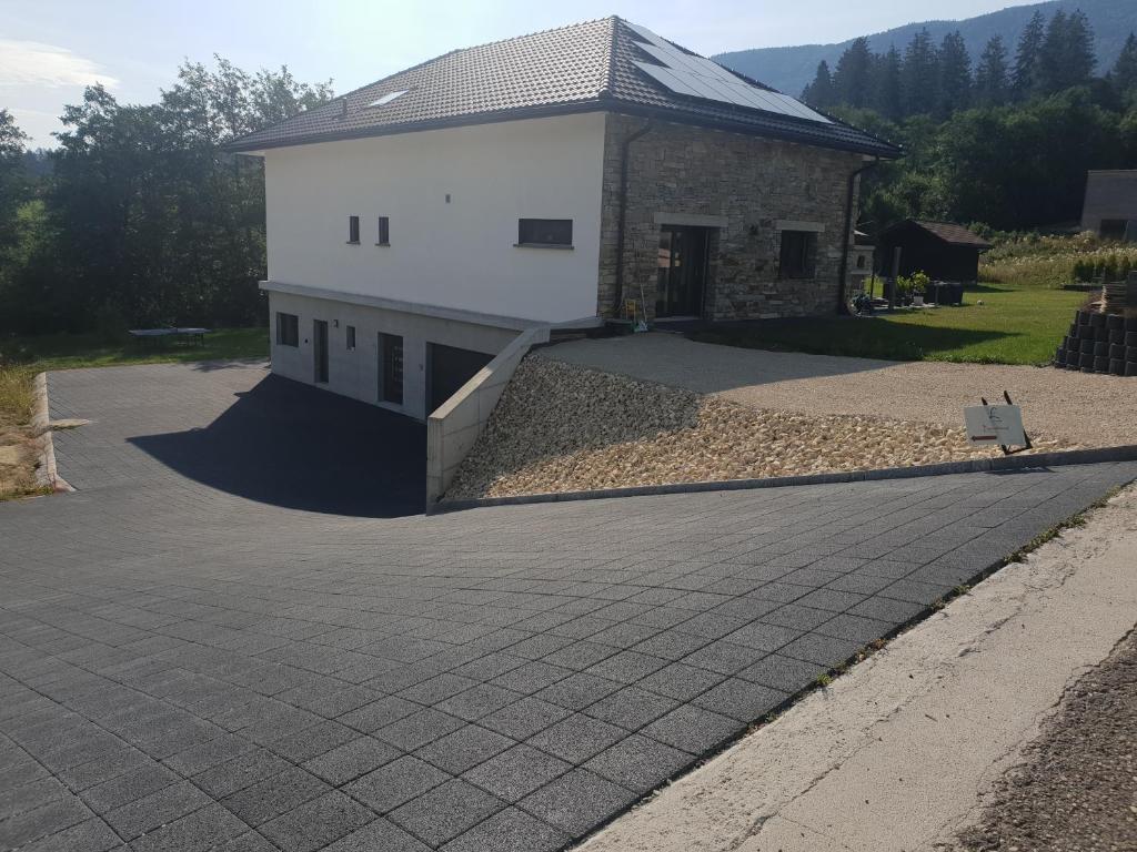 a house with a stone driveway in front of it at L'appartement in Reconvilier