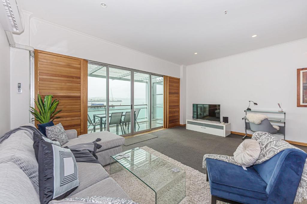 a living room with two couches and a television at Princes Wharf - Absolute Waterfront & Great Views in Auckland