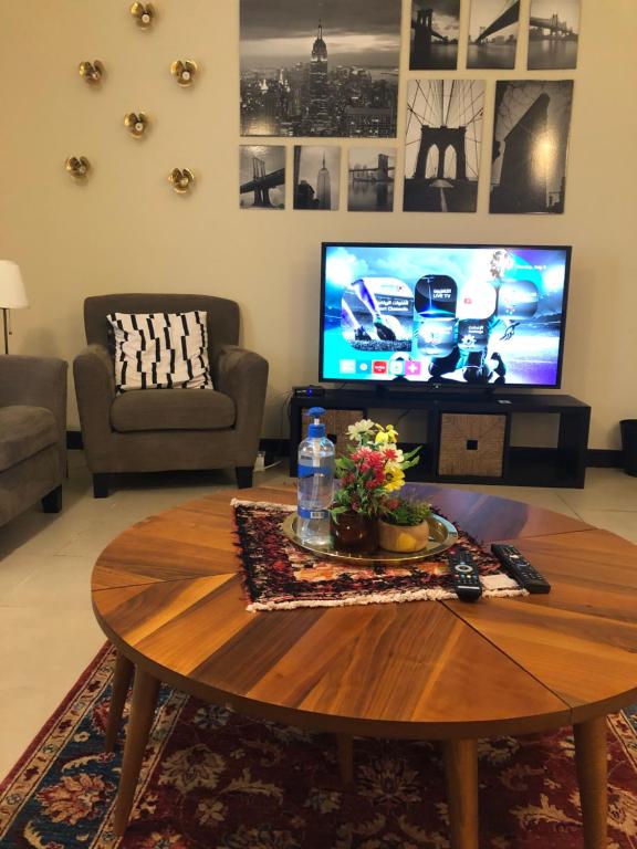 a living room with a coffee table and a television at شقة مارينا البيلسان - عائلات فقط in King Abdullah Economic City