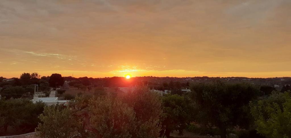 um pôr-do-sol com o pôr-do-sol sobre uma cidade em L'Alba della Tavernetta em Locorotondo