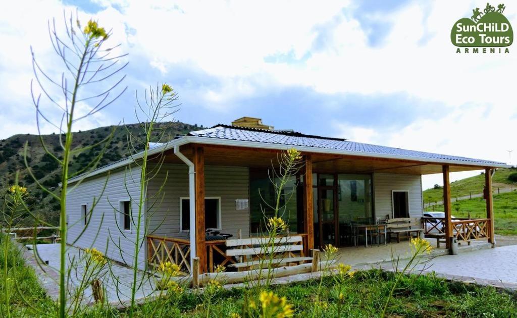 a small house with a porch and a patio at EcoLodge in Wildlife Refuge in Urtsʼadzor