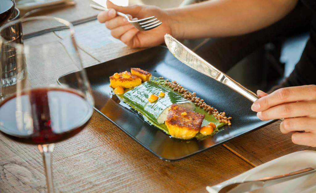 a plate of food on a table with a glass of wine at Staycity Aparthotels Dresden City Centre in Dresden