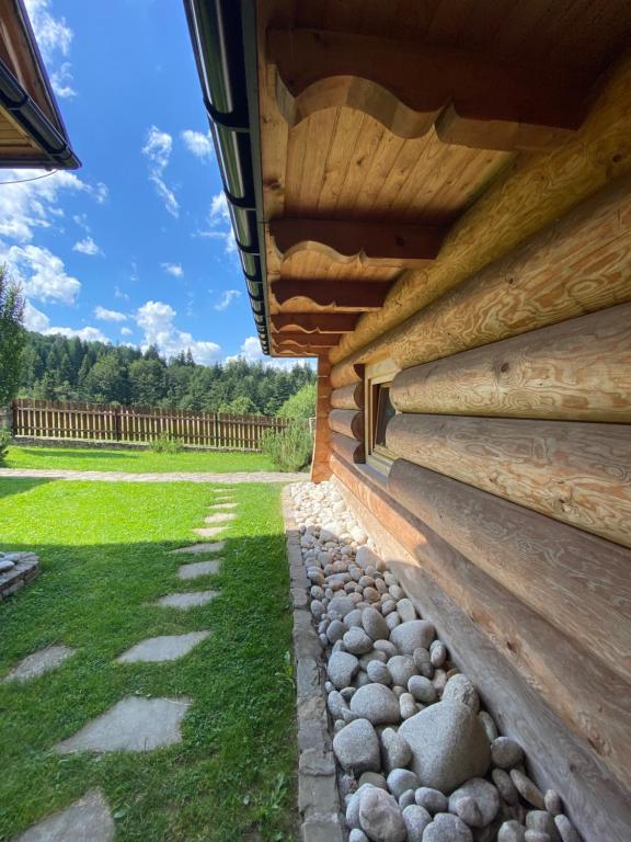 a wooden building with a fence in the background at Apartament Babia Góra in Zawoja