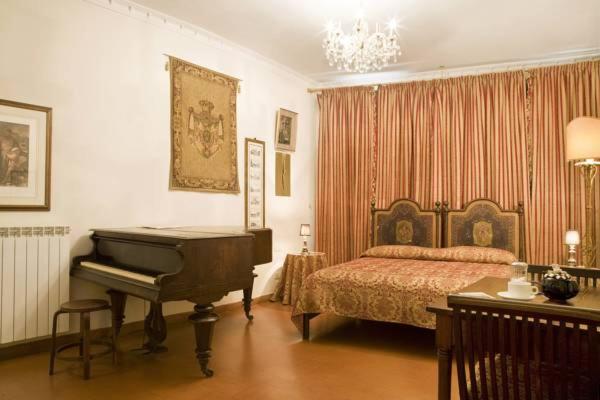 a bedroom with a bed and a piano in it at Lungarno Ponte Vecchio in Florence