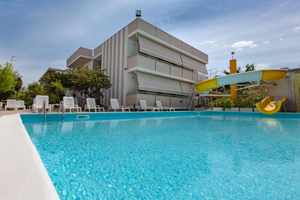 einem Pool mit Rutsche vor einem Gebäude in der Unterkunft Holiday Club Residence in Alba Adriatica