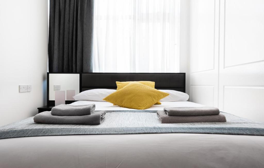 a bedroom with a large bed with yellow pillows at Central Hoxton Shoreditch in London