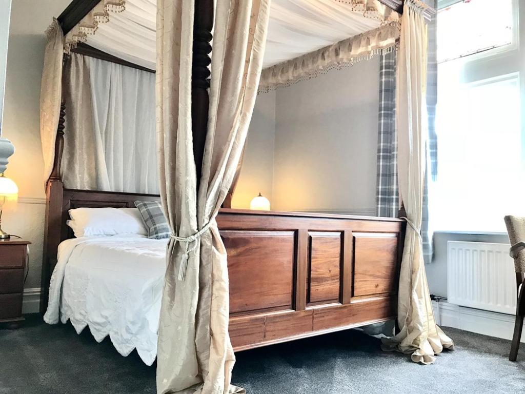 a canopy bed with curtains in a bedroom at The Red Lion in Matlock