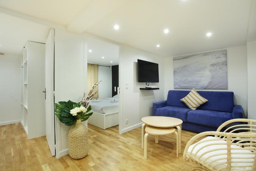 a living room with a blue couch and a bedroom at Rent a Room - Cosy 2BDR in Paris