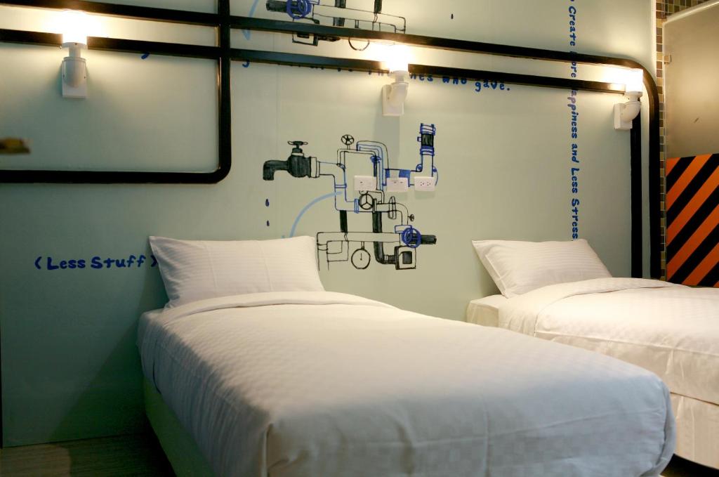 two beds in a room with a drawing on the wall at NL Concept Hotel in Kaohsiung