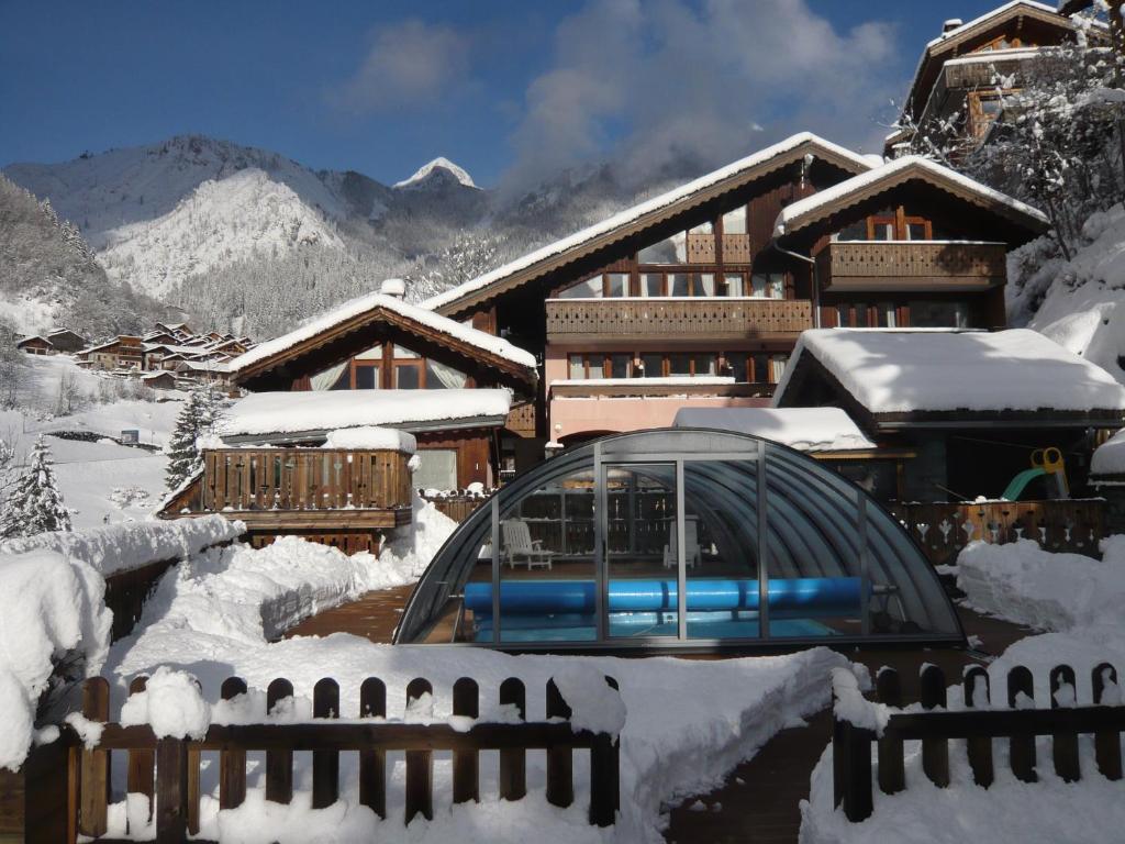 a building covered in snow with a fence at Résidence Les Edelweiss in Champagny-en-Vanoise