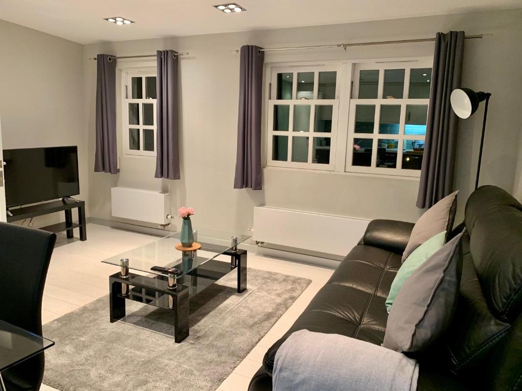 een woonkamer met een bank en een televisie bij Richmond House by Staytor Accommodation in Exeter