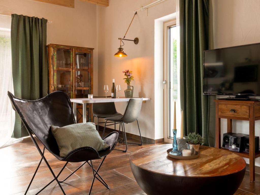 a living room with a table and a chair at Rochter Apartments in Zeltingen-Rachtig