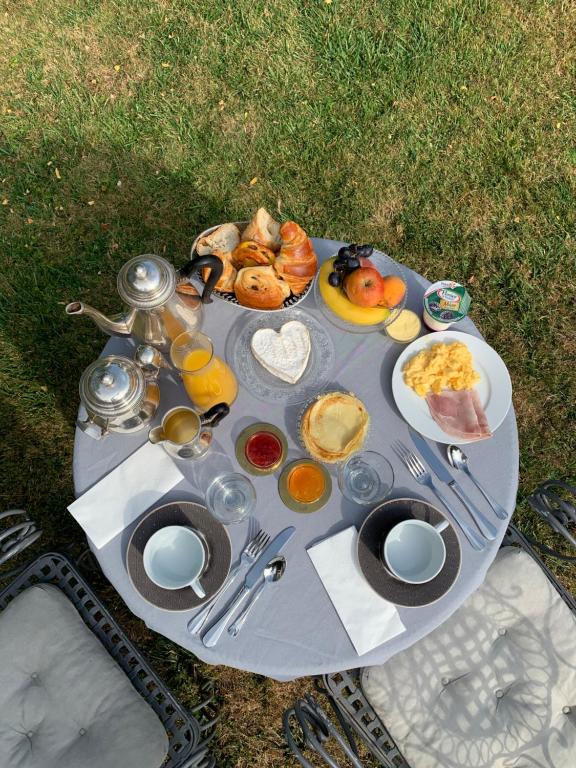 a picnic table with food and drinks on it at Le Tardif, Noble Guesthouse in Bayeux