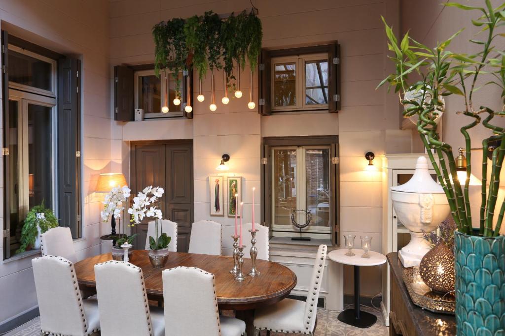 a dining room with a wooden table and white chairs at Marpessa Hotel & Spa in Agrinion