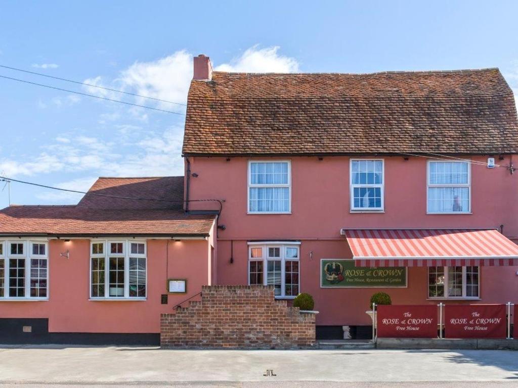 a pink house with a brown roof at The Rose and Crown in Thorpe le Soken