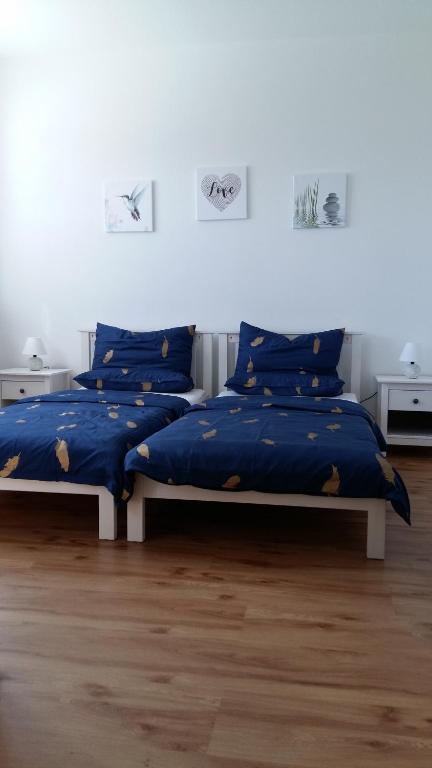 2 camas con sábanas azules en una habitación en Ferienwohnung Giovanni Studio en Schwandorf in Bayern
