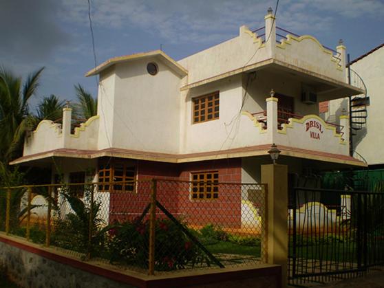 uma casa branca com uma cerca à frente. em Drisl Villa 3BHK em Alibag