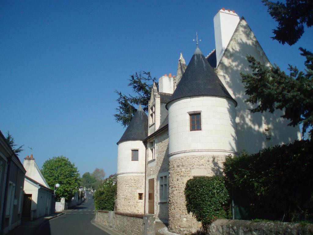 a building with a turret on the side of a street at Manoir du Rouvre in Mettray