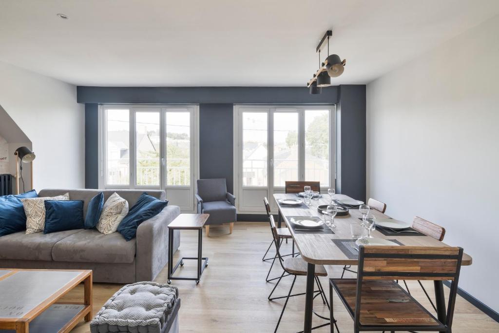 sala de estar con mesa y sofá en Le MoZen - Appartement proche hippodrome - St Malo, en Saint-Malo