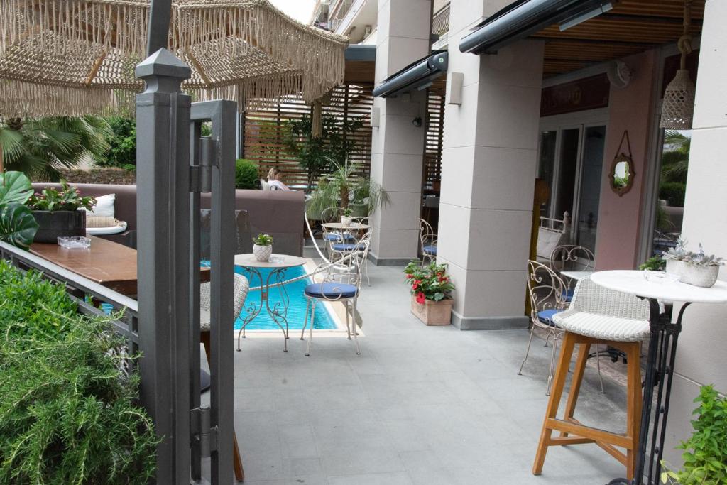 an outdoor patio with tables and chairs and a building at Marpessa Hotel & Spa in Agrinion