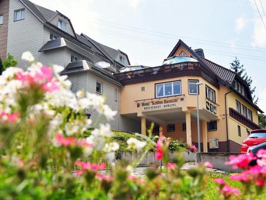 a large house with flowers in front of it at Hotel Schöne Aussicht in Steinach