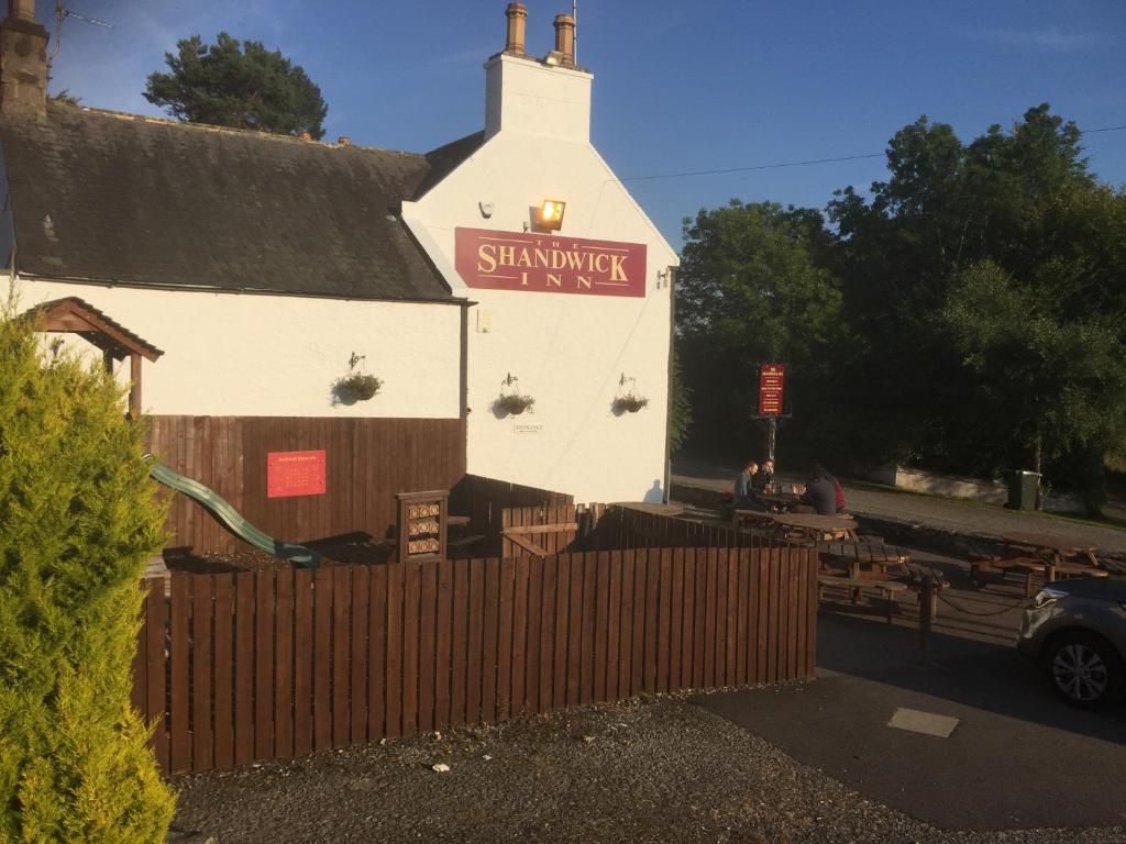 a white building with a sign on the side of it at The Shandwick Inn in Tain