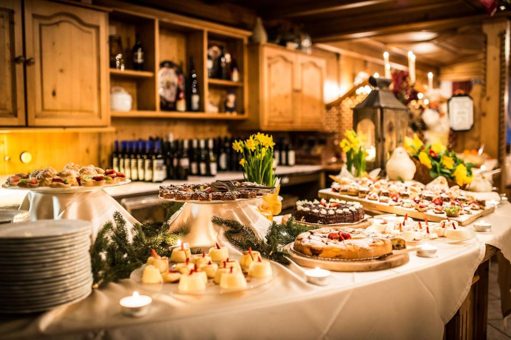 stół z wieloma różnymi rodzajami jedzenia na nim w obiekcie Hotel Ciasa Tamá w mieście La Villa