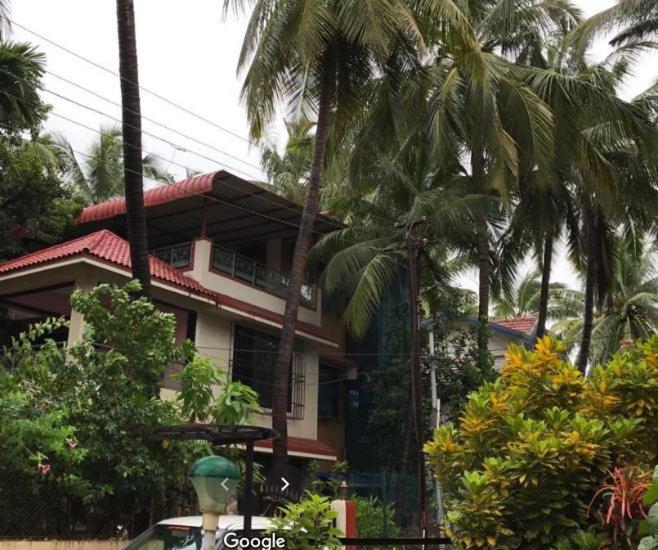 uma casa com palmeiras em frente em Swapnapurti Bungalow 2BHK em Alibaug