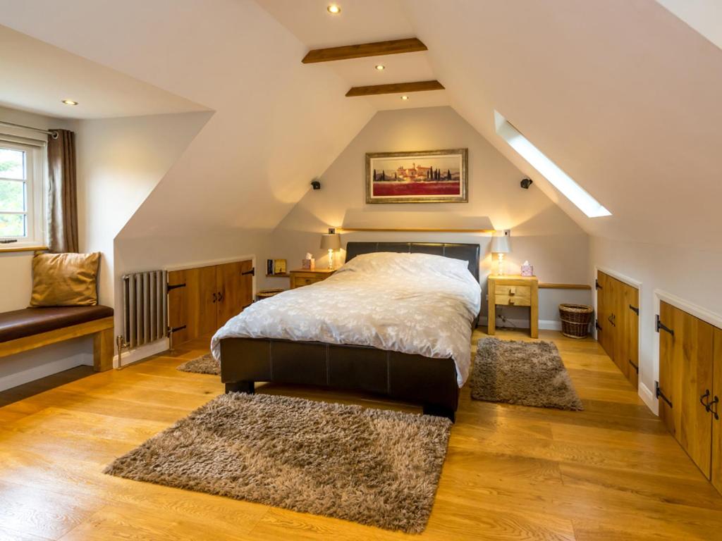 Schlafzimmer im Dachgeschoss mit einem Bett und 2 Teppichen in der Unterkunft Souters Cottage Annexe in Chichester