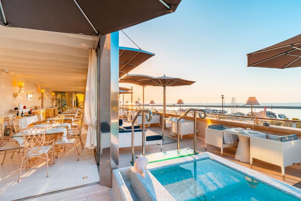 a hotel room with a pool, chairs, and tables at Palazzo del Corso – Boutique Hotel in Gallipoli