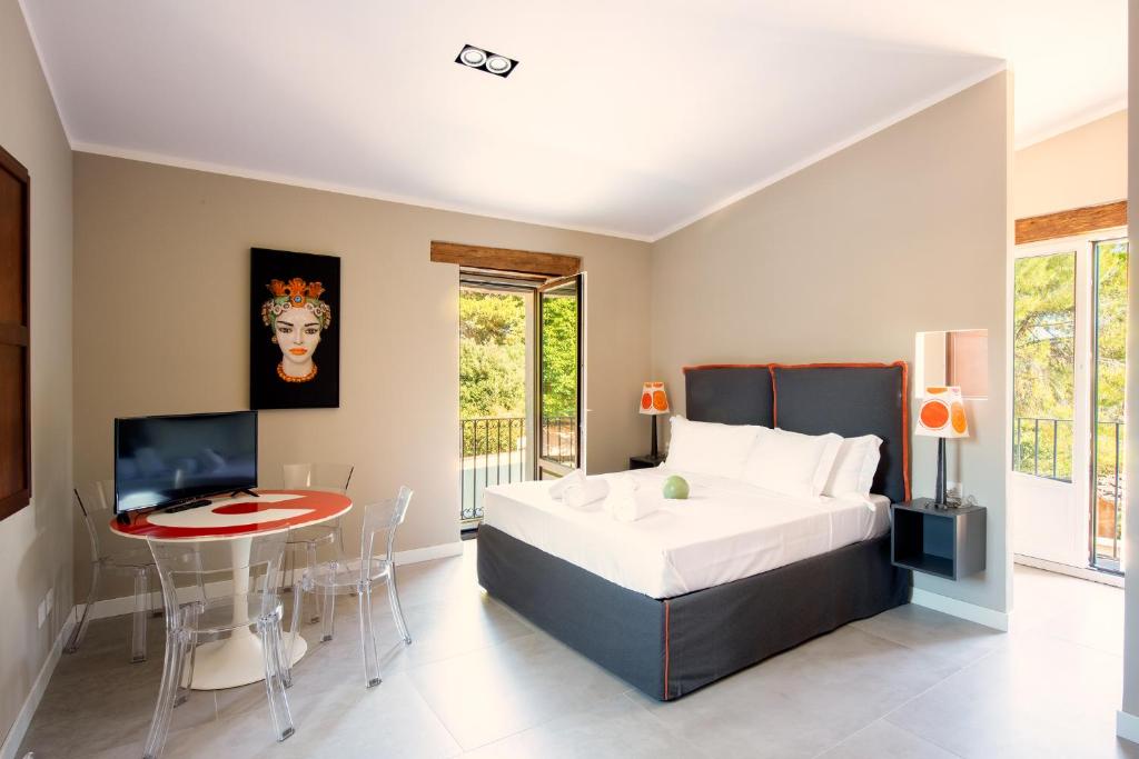 1 dormitorio con cama, mesa y TV en MOMENTO-TEATRO GRECO, en Siracusa