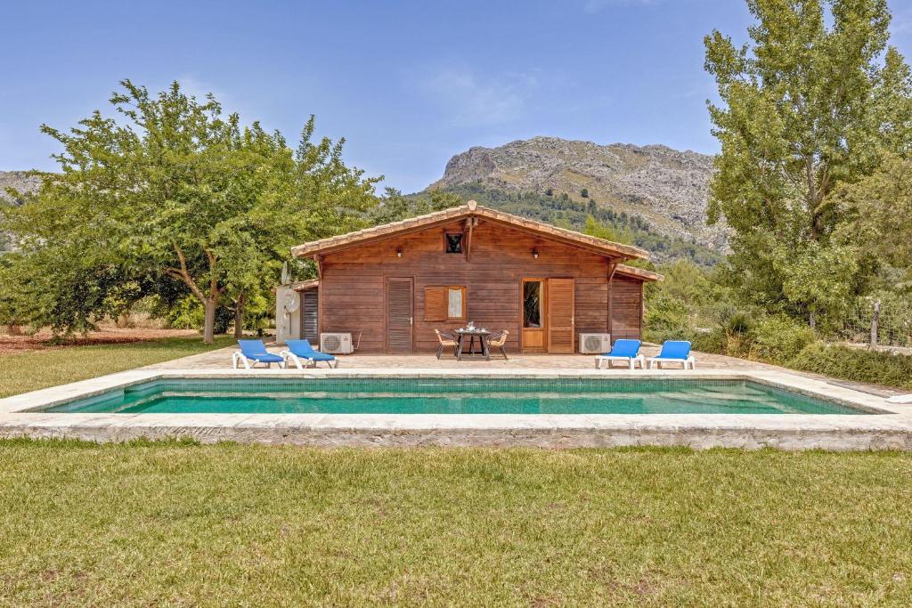 a log cabin with a pool in front of a house at Finca L'hort Nou in Pollença